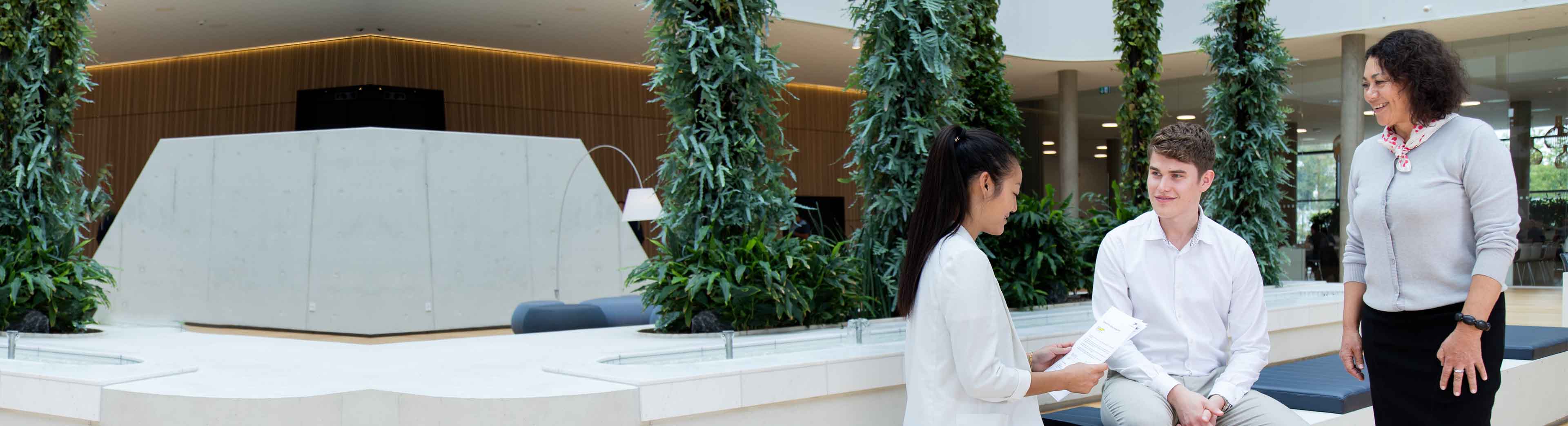 Two young trainees and an experienced colleague in a discussion at the DSV headquarter in Hedehusene